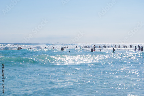 Rough sea with swimmers in backlight