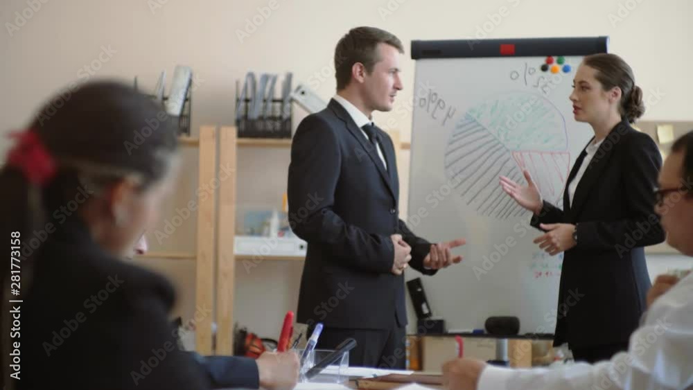 A man and a girl of Caucasian appearance in business suits, discuss business issues at the meeting A man and a girl of Caucasian appearance in business suits, discuss business issues at the meeting