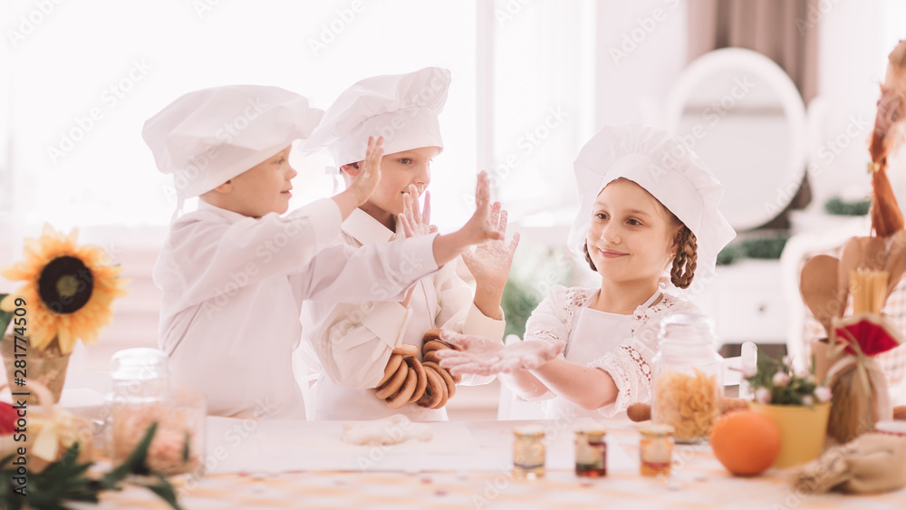 kids in chef uniform giving each other a high five kids in chef uniform giving each other a high five