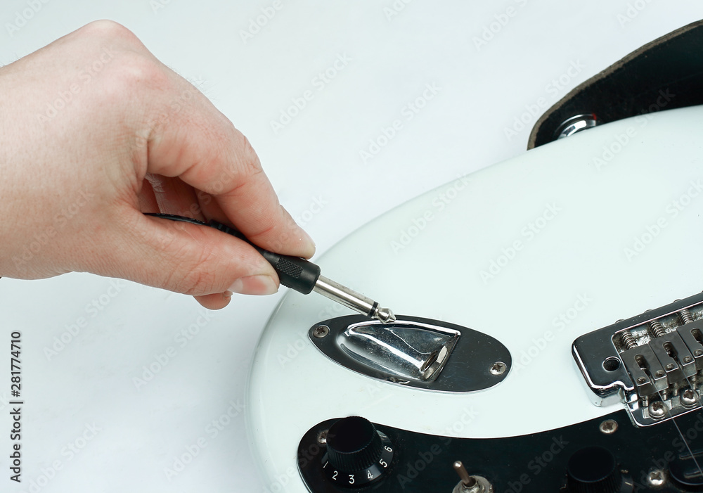 closeup. rock guitarist connecting the cord to the guitar. closeup. rock guitarist connecting the cord to the guitar.