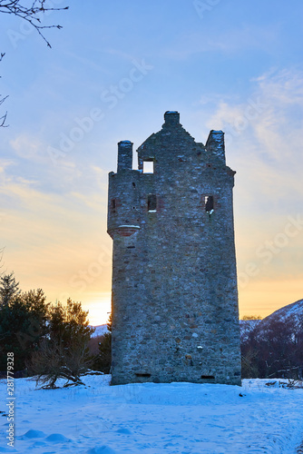 The Tower of Invermark Castle situated at the Foot of Glen Esk in the Angus Glens, under the setting sun on a Winters day with snow on the ground. photo