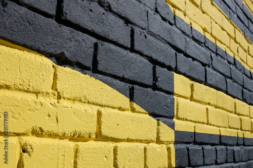 Brick wall painted in yellow and black