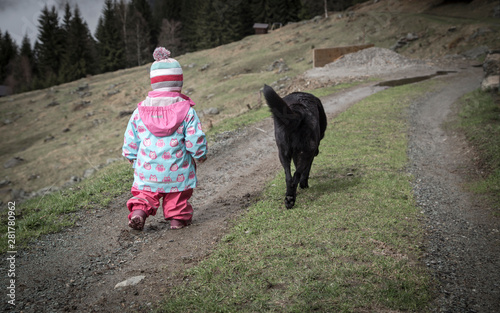 Obraz na płótnie The friendship between a child and her black dog w salonie