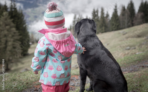 Obraz na płótnie The friendship between a child and her black dog w salonie
