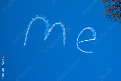 The word ME written large in a bright blue sky by a sign writing plane.
