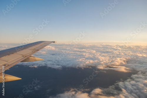view from airplane window on fluffy white clouds at sunrise 1