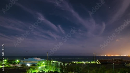 Timelapse of clouds over coastal city at night, Okinawa, Japan photo