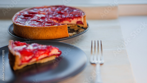 Classic cheesecake with strawberry slices in jelly on top.