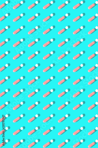 Pink and white pills on blue background.