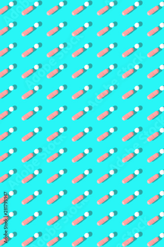 Pink and white pills on blue background.