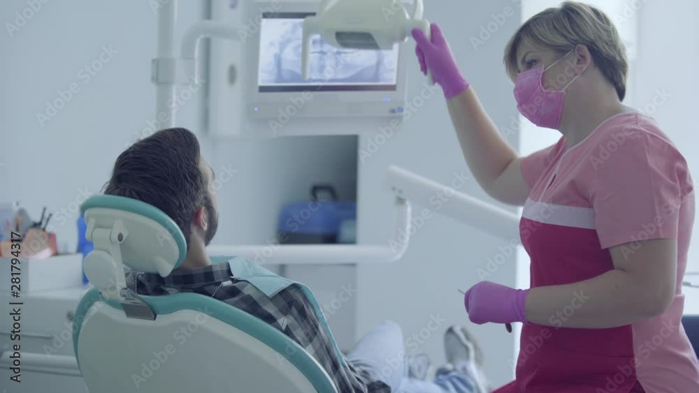 Dentist in medical mask and gloves checking the mouth of the patient using medical tools in a modern dental office. Female professional doctor stomatologist at work. Dental treatment, medical concept. Dentist in medical mask and gloves checking the mouth of the patient using medical tools in a modern dental office. Female professional doctor stomatologist at work. Dental treatment, medical concept.