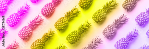 Fresh pineapples on vibrant rainbow gradient background. Top View. Pop art design, creative concept. Copy Space. Neon pineapple pattern for minimal style.