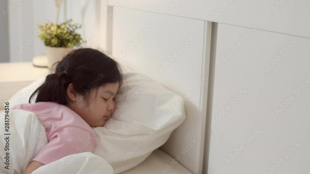 Young Asian girl sleeping at home. Asia japanese woman child kid relax rest  asleep lying on bed, feel comfort and calm in bedroom at home at night  concept. Slow motion shot. Stock