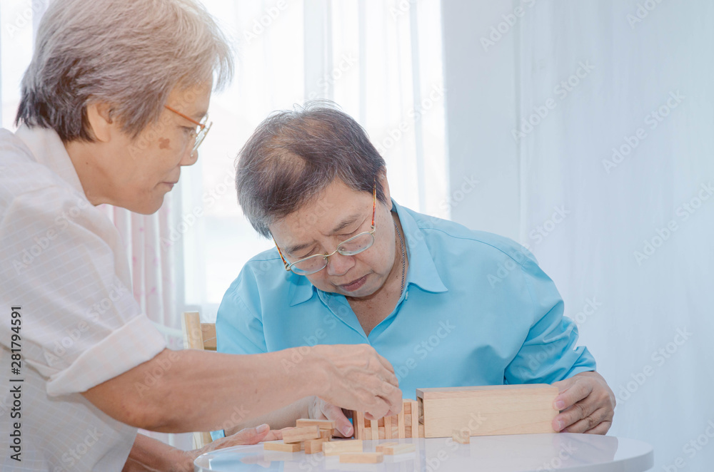 Obraz premium Asian elderly women Wearing a blue shirt And friend are playing games Have fun in the morning at home in the room.
