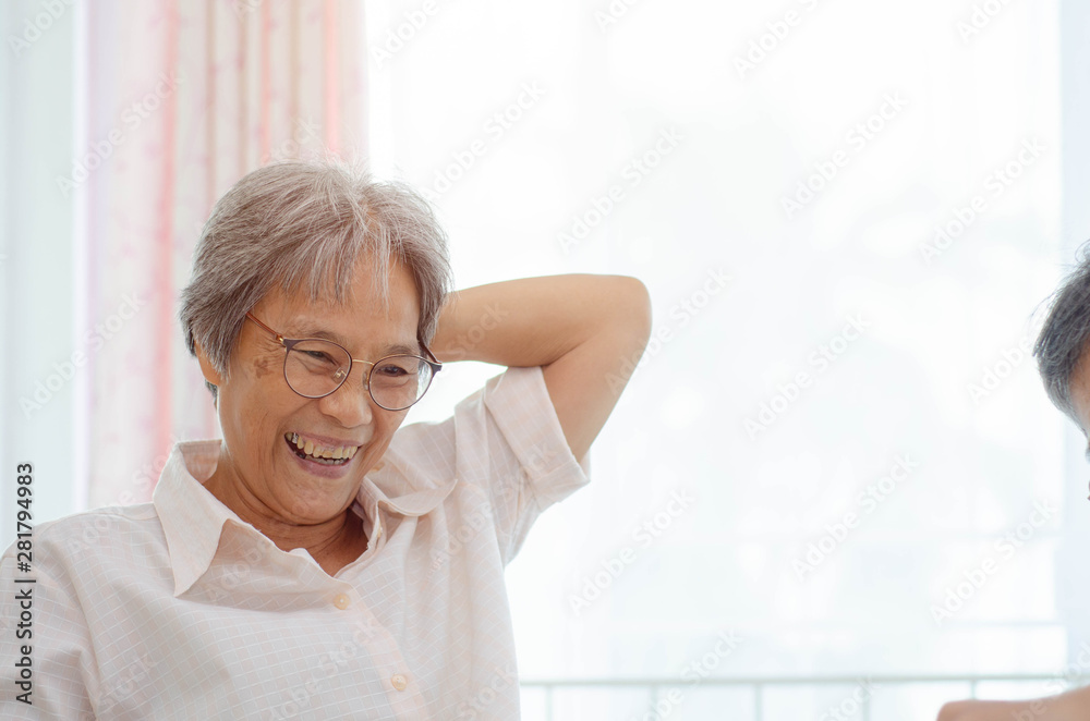 Asian elderly women Wearing a blue shirt And friend are playing games Have fun in the morning at home in the room. Asian elderly women Wearing a blue shirt And friend are playing games Have fun in the morning at home in the room.