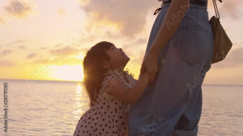 Mother with¬†daughter¬†hoping in sea at sunset photo