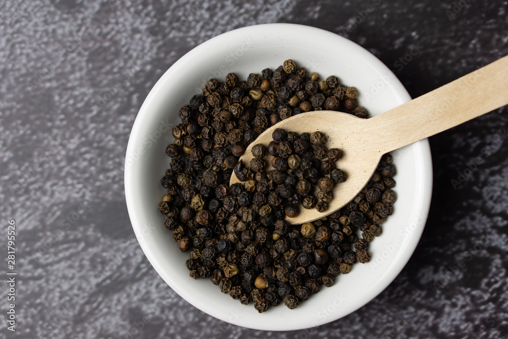 Black pepper in a bowl on dark background. Black pepper in a bowl on dark background.