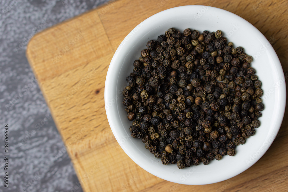 Black pepper in a bowl on dark background. Black pepper in a bowl on dark background.