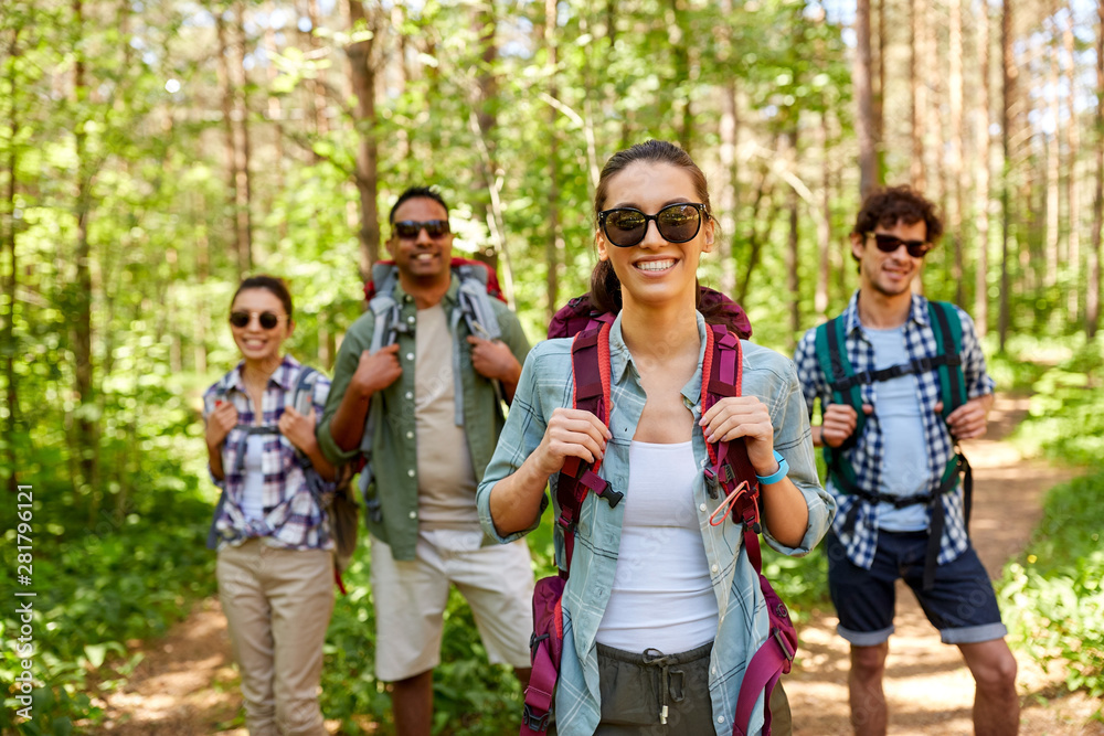 travel, tourism, hike and people concept - group of friends with backpacks in forest travel, tourism, hike and people concept - group of friends with backpacks in forest