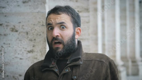 witty latin man making the gesture of fear and shock- outdoor