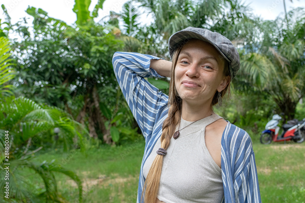 Closeup caucasian girl face in the cap. Portrait of young woman in nature