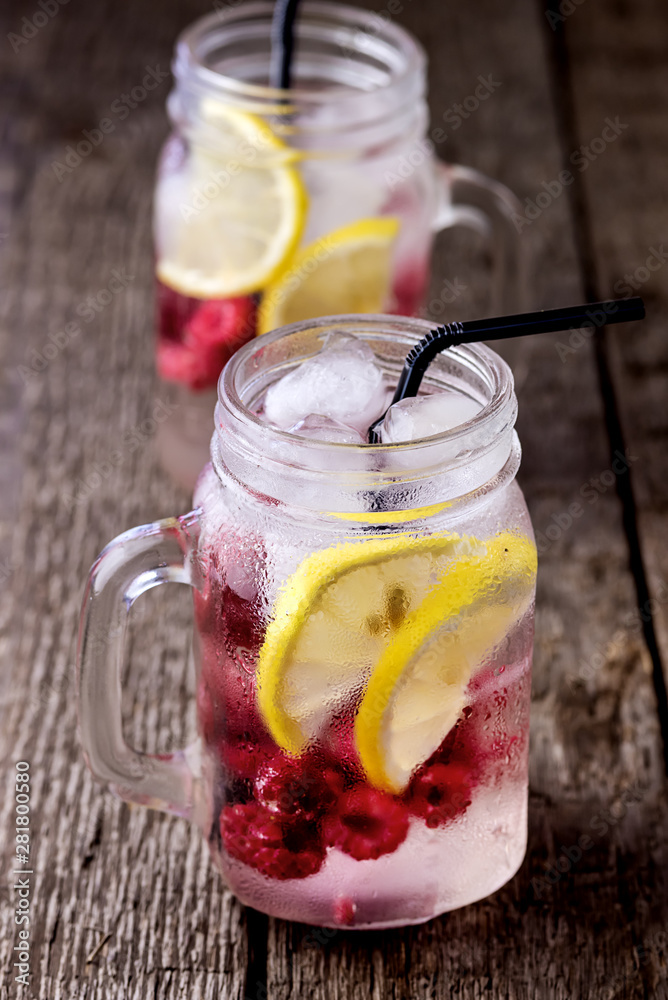 Infused Water with Lemon and Raspberry Healthy Detox Drink Cold Berry Fruit Lemonad in Glass Jars Wooden Background Vertical