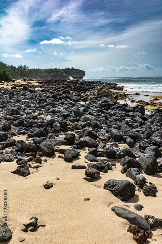 Lava rocks on the sand beach, Keoniloa Bay, Kauai, Hawaii photo