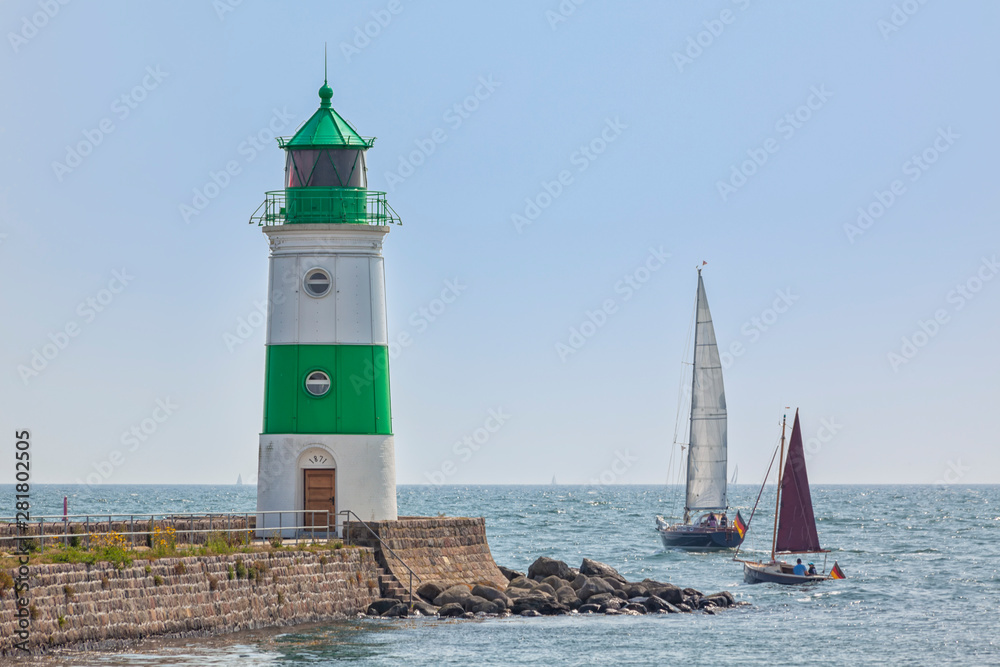 Sailboats passing by Schleimünde lighthouse between Schlei inlet and Baltic Sea