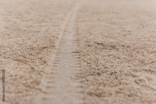 Background texture of car tyre track on sandy beach.