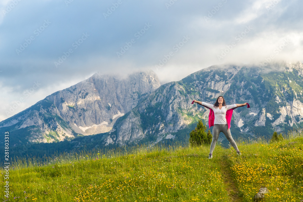 Fototapeta premium happy European girl stands on background of Montenegro mountains in Durmitor park, with copy space