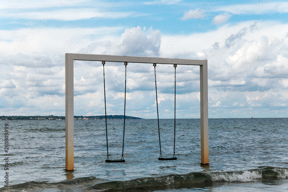 Couple swing on beautiful sea shore and beach, Sweden, Helsingborg Couple swing on beautiful sea shore and beach, Sweden, Helsingborg