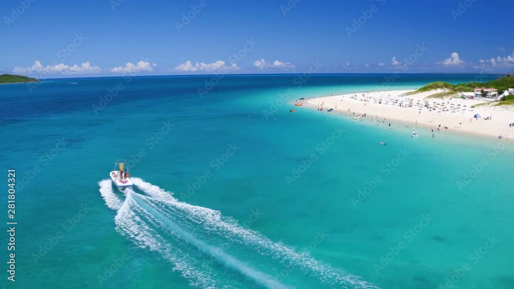Drone view of motorboat sailing past crowded beach of Miyako Island