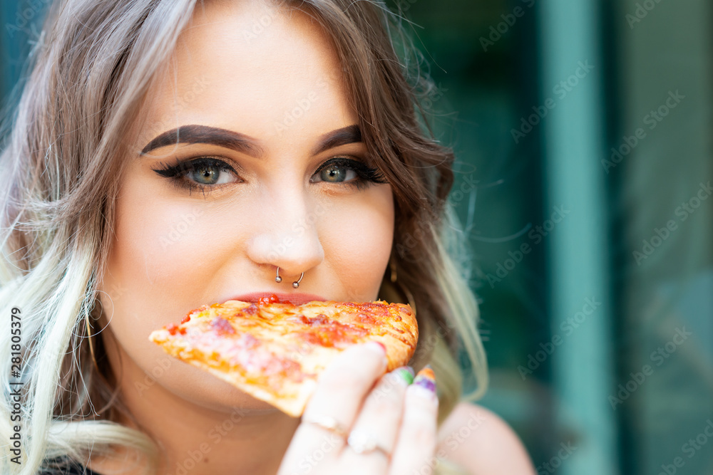 Beautiful Young Woman eating Slice of hot fresh Pizza. Popular Fast Food concept.