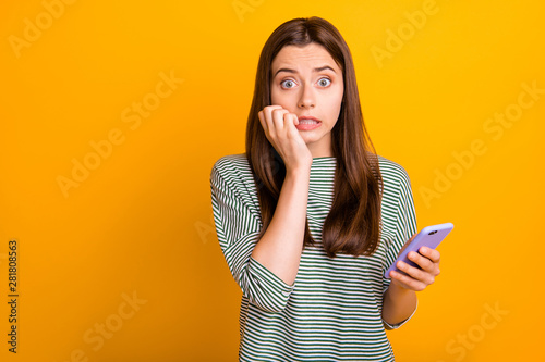 Photo of worried concerned girlfriend seeing her phone screen cracked and shattered to pieces while isolated with yellow background