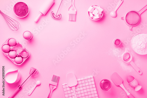 Bakery ingredients over trendy neon pink color background - butter, sugar, flour, eggs, oil, spoon, rolling pin, brush, whisk, towel. Baking frame, cooking concept. Top view, copy space. Flat lay