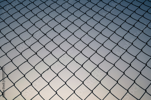 Old metal mesh against the evening sky. Abstract background 
