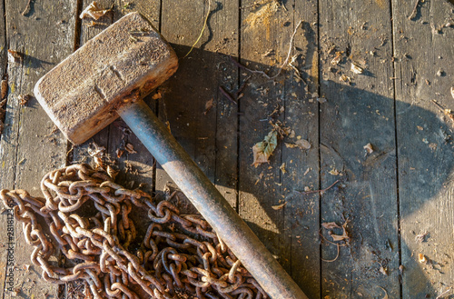 Rusty chain and old hammer on on gray stones. A torn chain is a symbol of liberated labor. photo