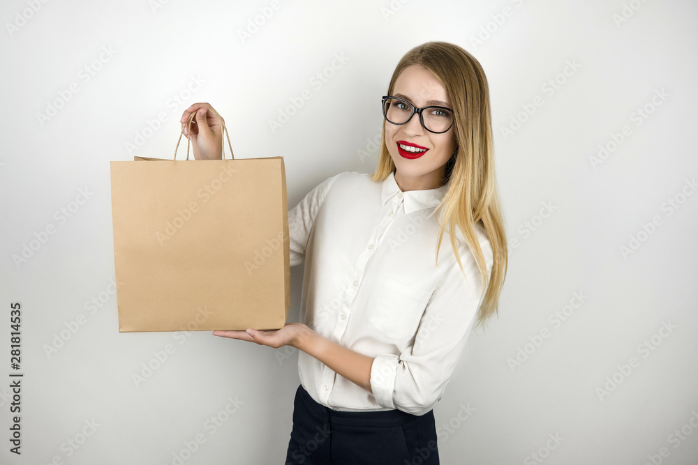 Φωτογραφία young beautiful business woman in eyeglasses holding awaited lunch in paper craf