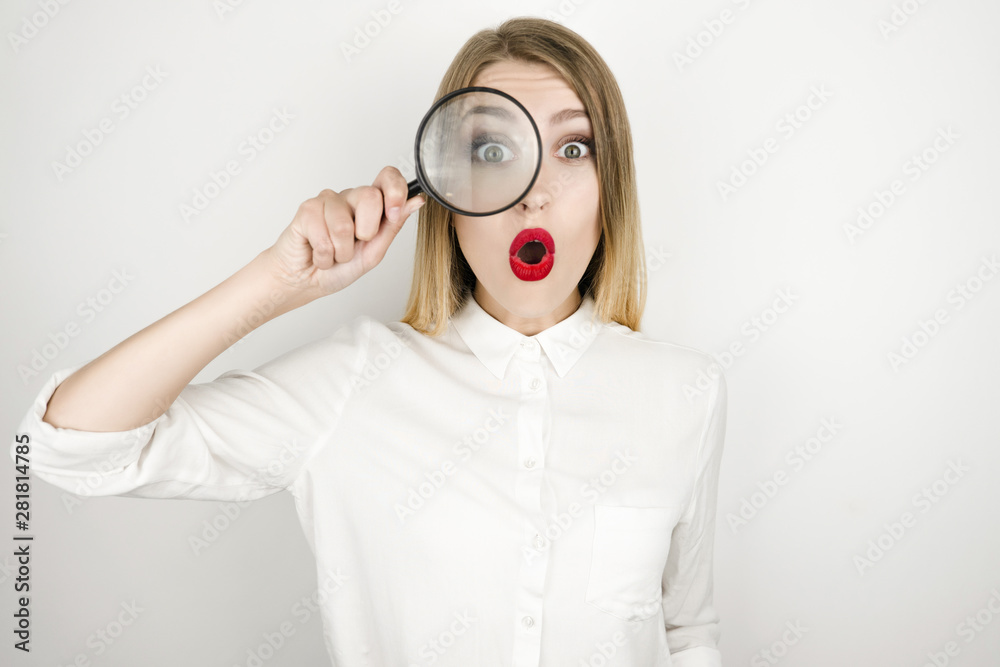 Φωτογραφία young beautiful blonde woman holding magnifying glass near her eye looks surpris