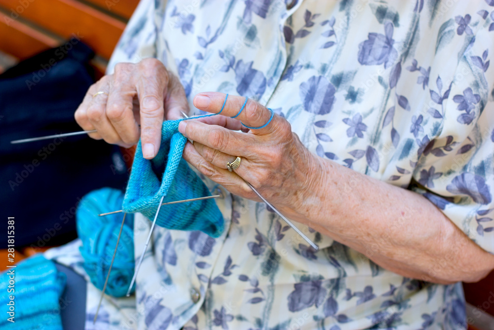 Pensioner, retiree concept, old retiree woman in her spare time knits socks for her grandchildren, the concept of a happy  life in old age, fulfilling life in old age