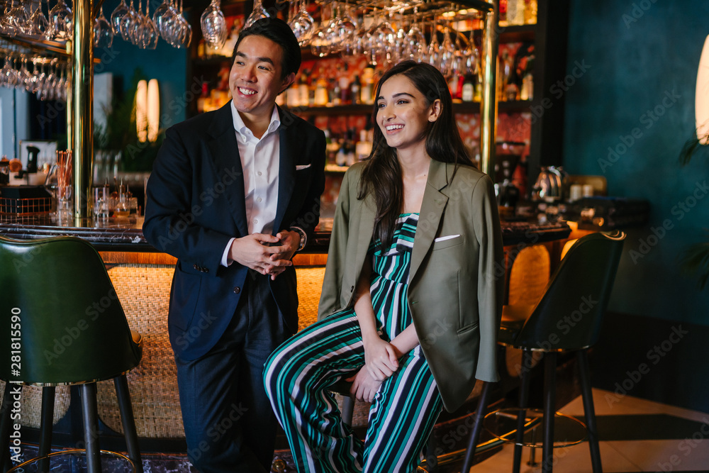 Φωτογραφία A photogenic young diverse Asian couple enjoy a drink at a classy bar