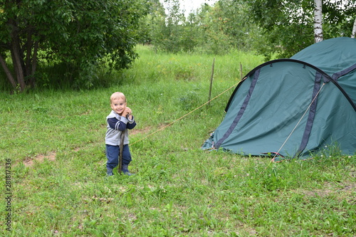 A little boy camping with a tent