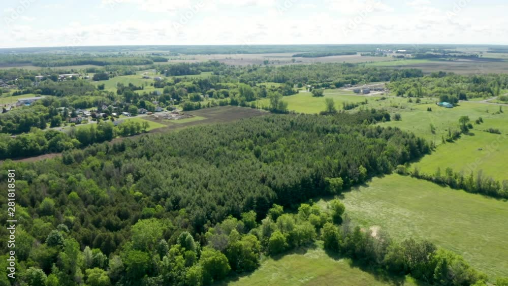 Wide aerial view of rural farms and land with green fields and dense woods. Drone flying high above the Canadian landscape near Moose Creek. Wide aerial view of rural farms and land with green fields and dense woods. Drone flying high above the Canadian landscape near Moose Creek.