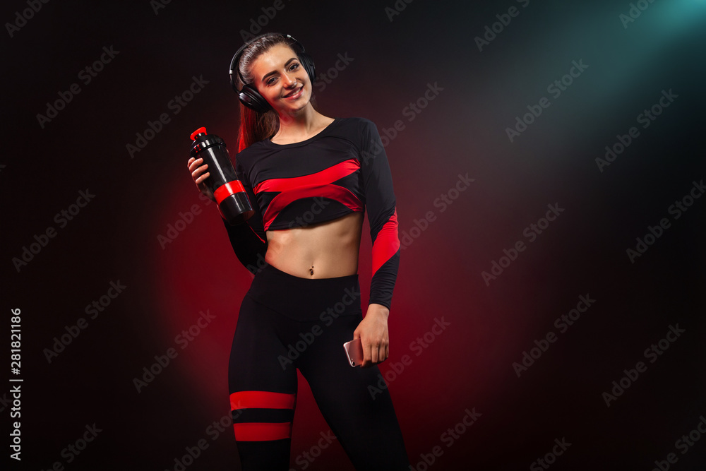 Sporty fit woman, athlete with dumbbells makes fitness exercising on red background. Fitness and workour motivation.