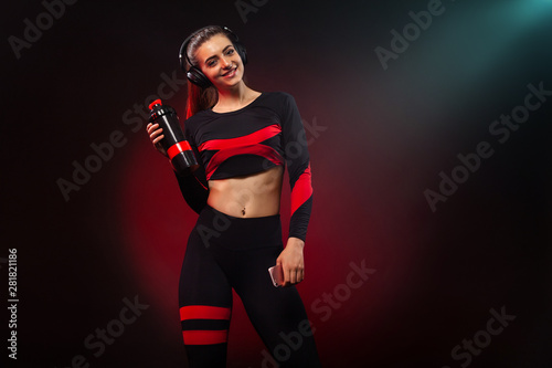 Sporty fit woman, athlete with dumbbells makes fitness exercising on red background. Fitness and workour motivation.