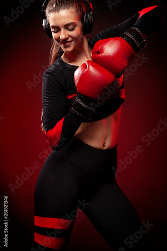 Happy and smiling young woman sportsman boxer on boxing training. Girl wearing gloves, sportswear.