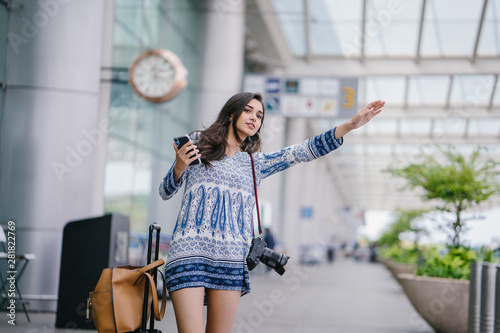 Photography A beautiful, young and confident Indian Asian woman is flagging her ride  that she booked on her ride-hailing app on her smartphone