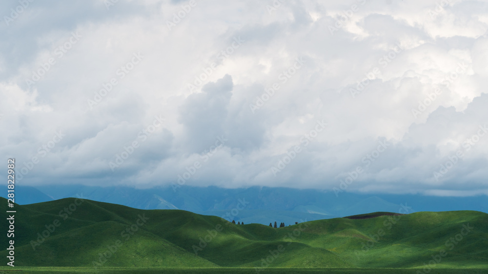 landscape with mountains and clouds，Blue sky, white clouds, and light projected through the clouds make the human grassland curve more beautiful.