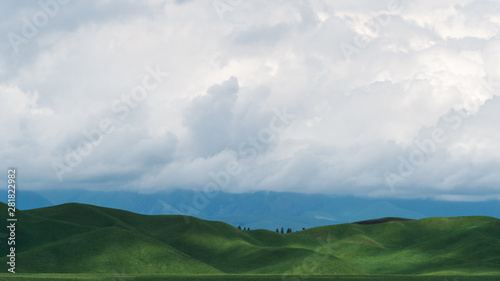 landscape with mountains and clouds，Blue sky, white clouds, and light projected through the clouds make the human grassland curve more beautiful. © Criss