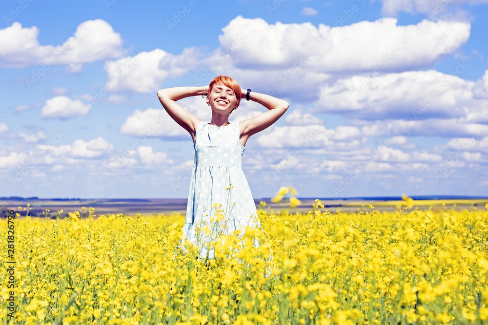 cute smiling red-haired girl in a dress on a flower meadow cute smiling red-haired girl in a dress on a flower meadow